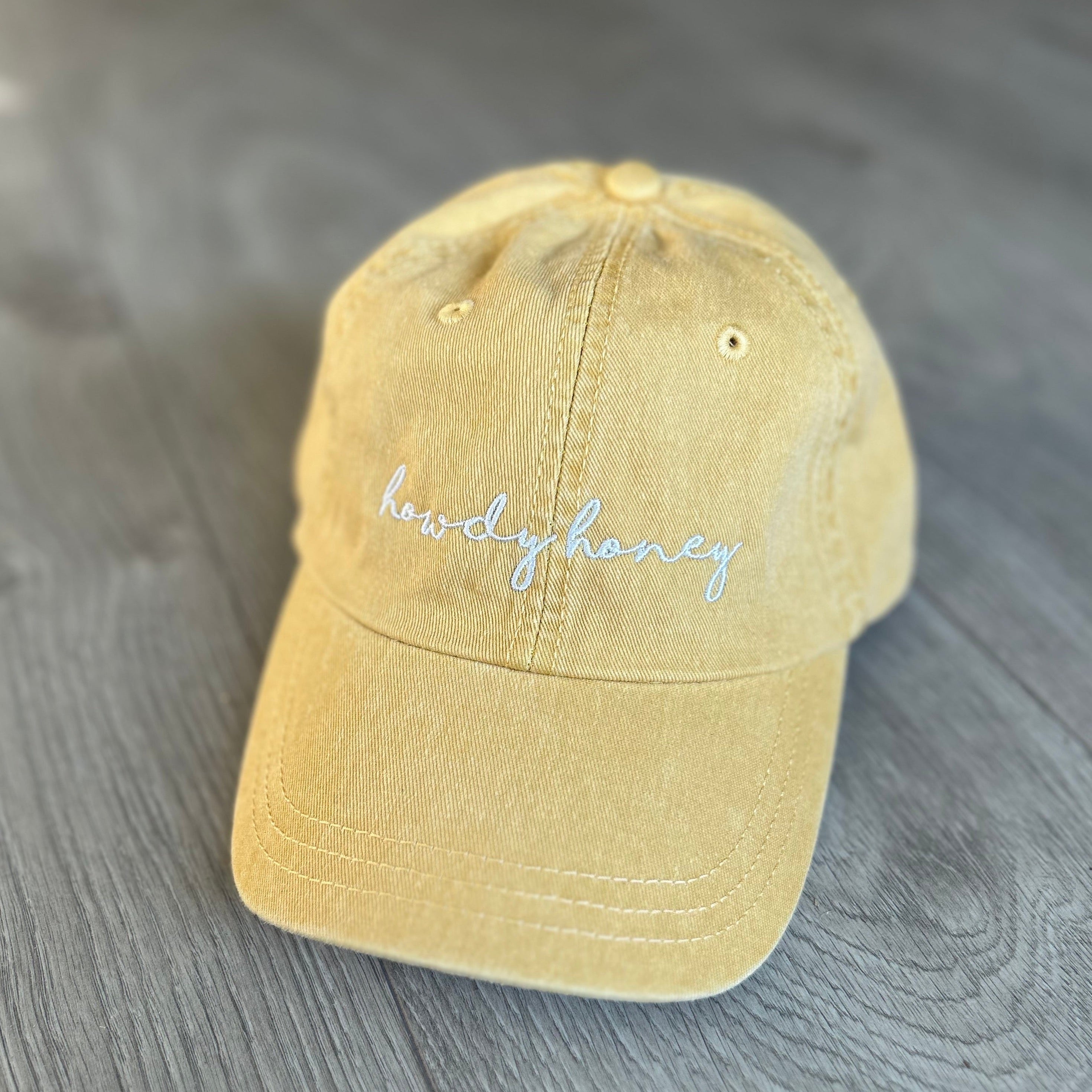 Yellow baseball cap with embroidered text "Howdy Honey" in white