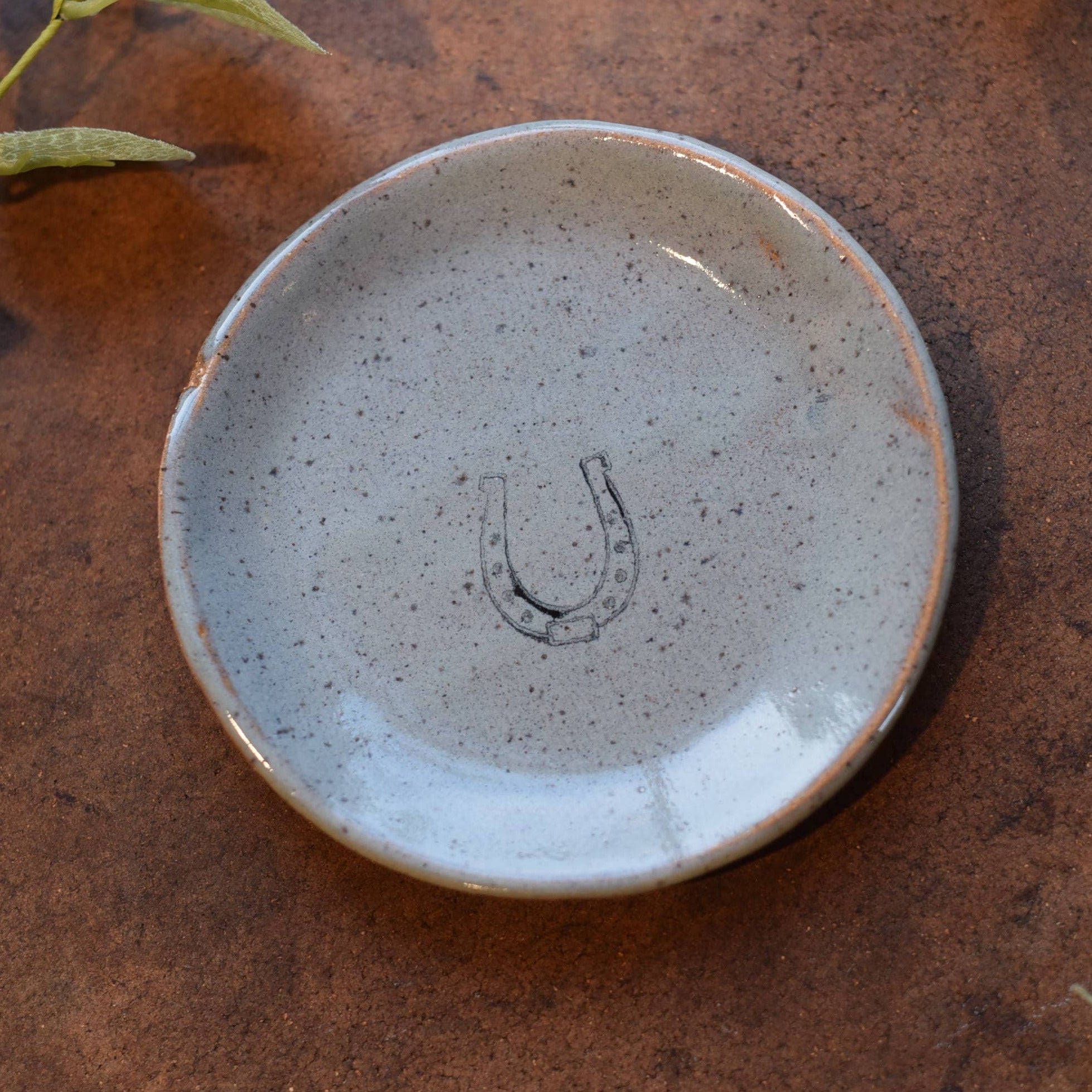 White small plate with printed horse shoe in center