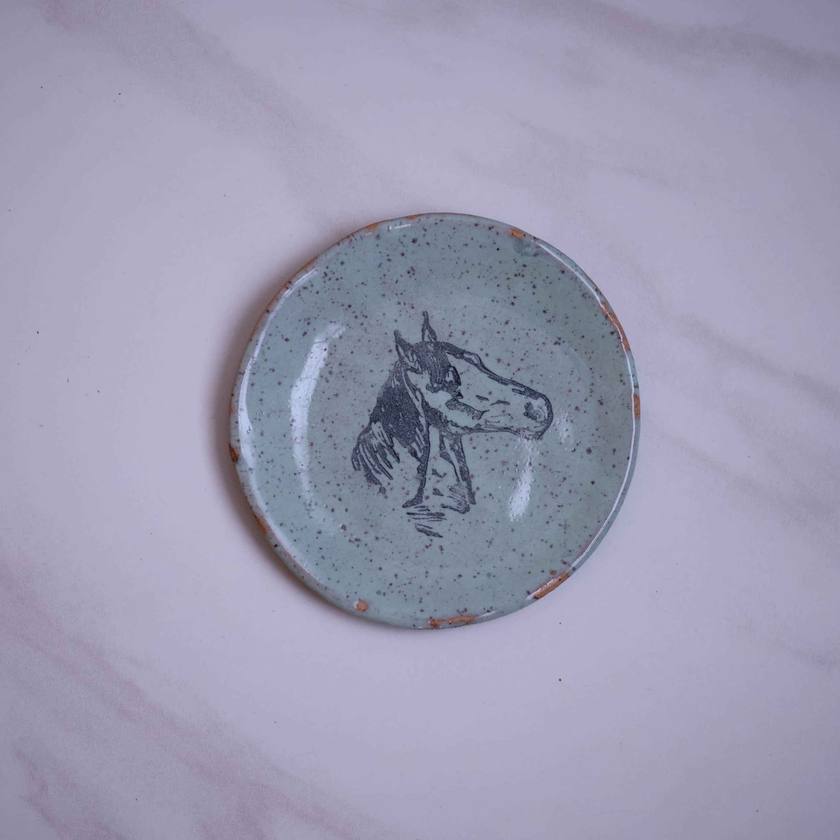 Blue small plate with large printed horse head in center
