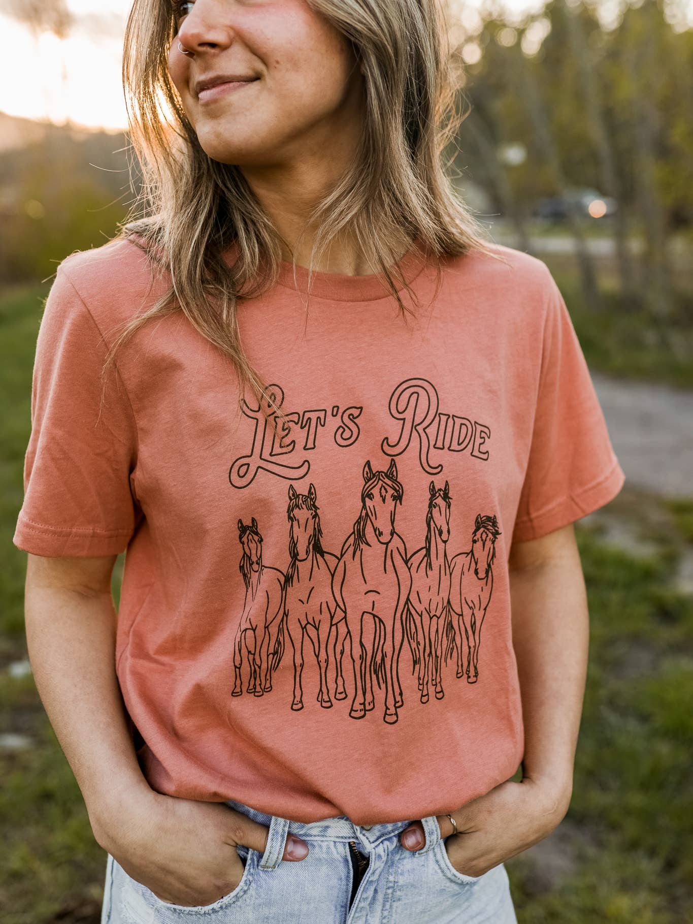 Terracotta t-shirt with "let's ride" in black lettering. 5 wild horses in black underneath