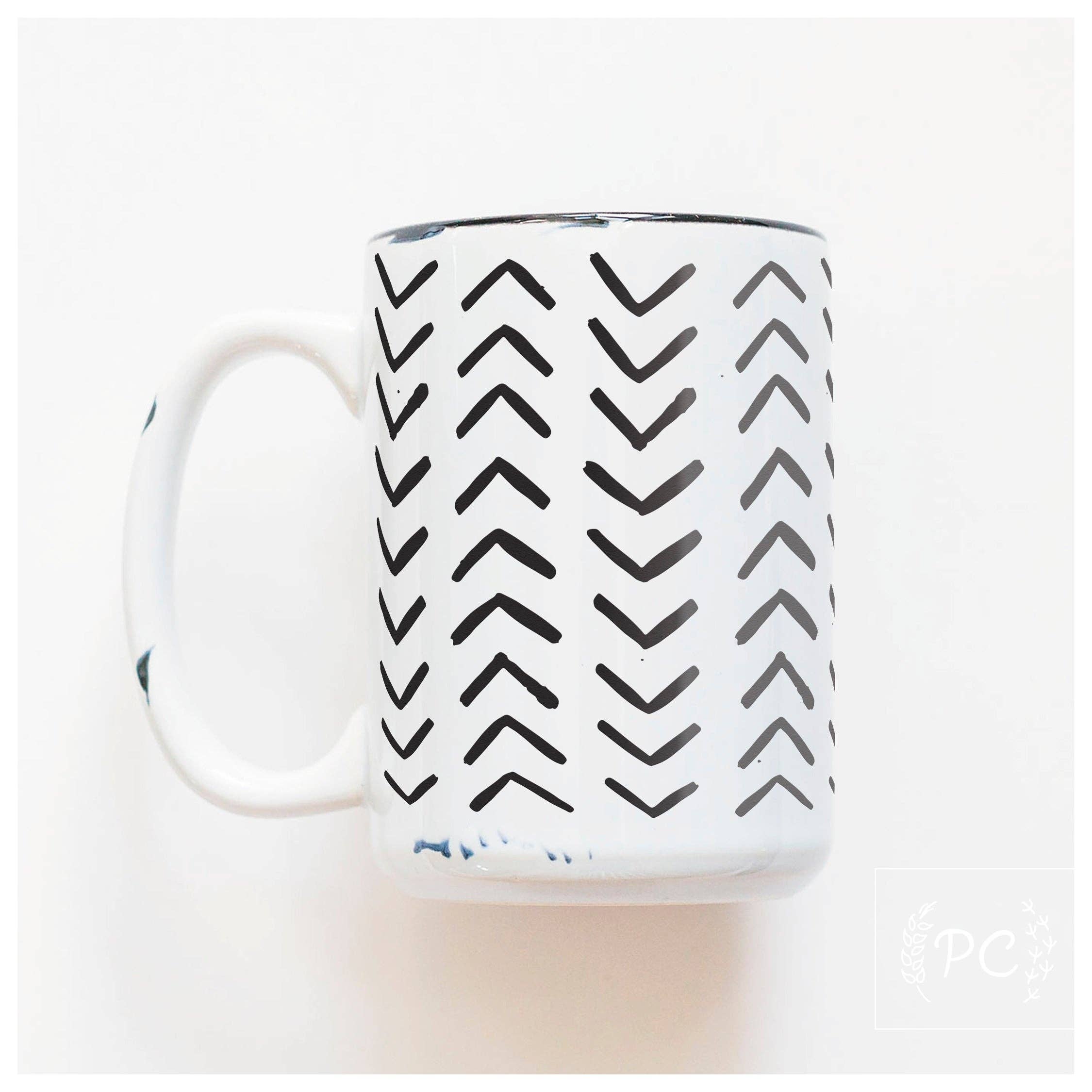 White mug with black ^ lines facing up and down